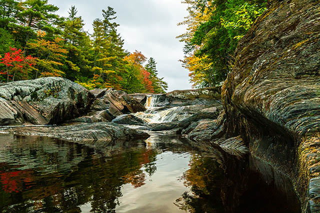 Les chutes Mill Falls coulent doucement sur les rochers à l'automne.