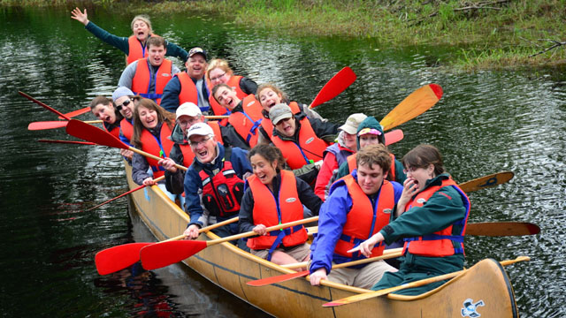 A group of people in a big canoe. 