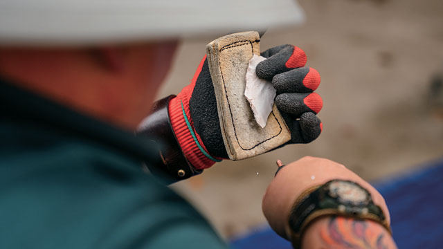 Une personne tenant un morceau de silex et un couteau