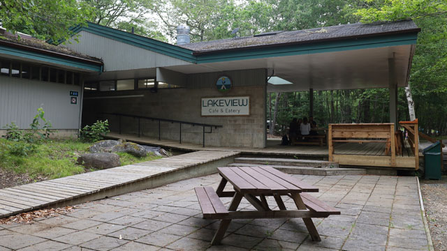 Le bâtiment du restaurant avec une rampe et des sièges extérieurs.