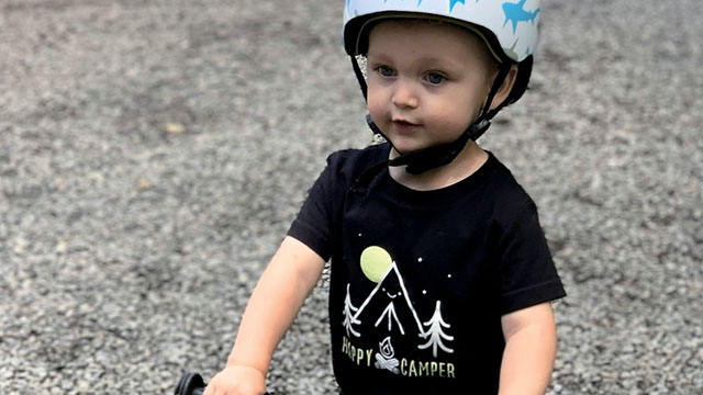 Un enfant sur un vélo porte un casque.