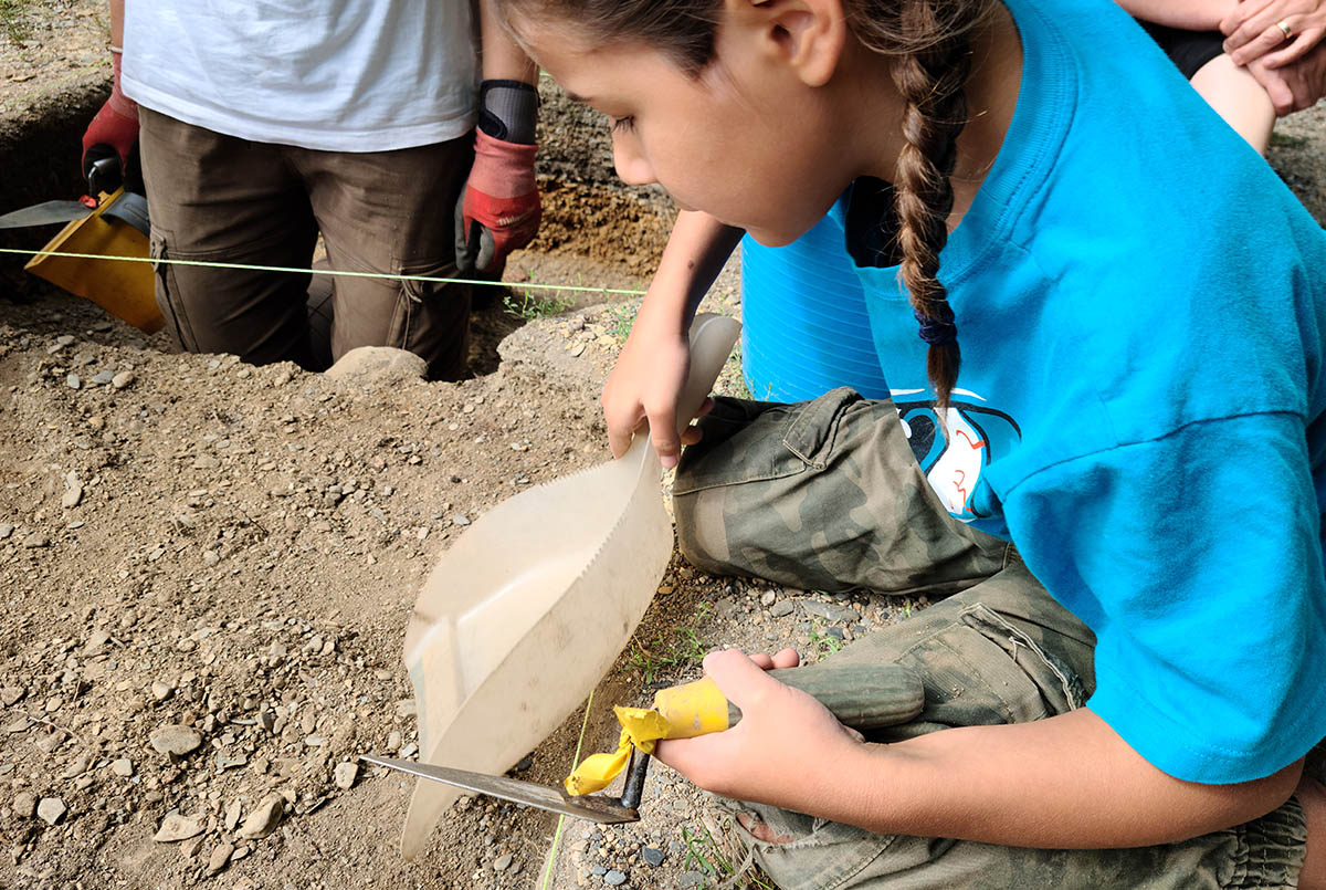 Un enfant creusant sur un vrai site archéologie.