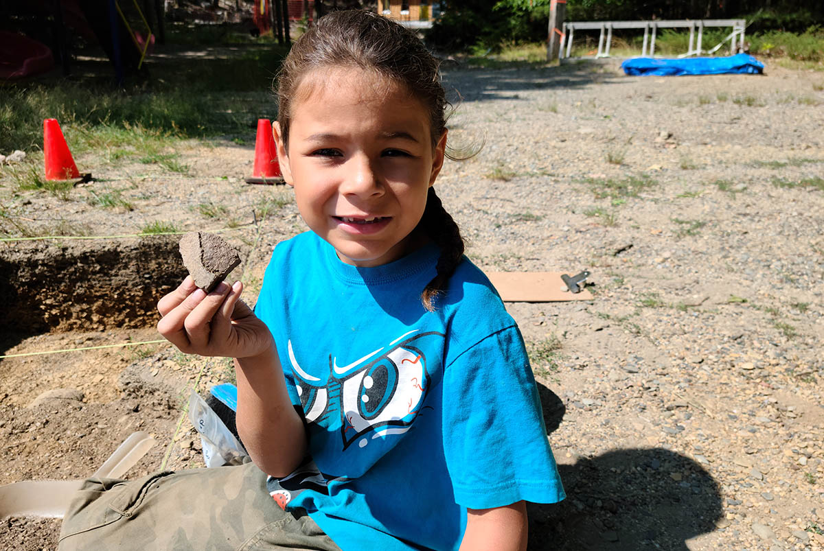 A child holding an artifact.
