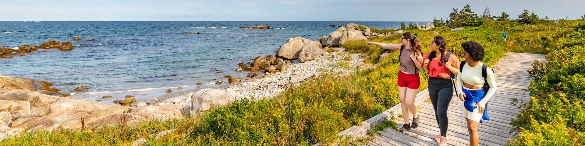 Three people hiking near the beach.