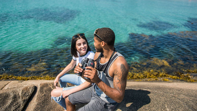 A man and a woman relax by the seaside.