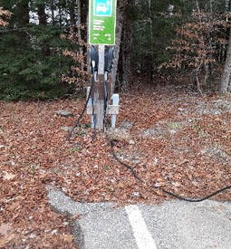 The EV charging station is located in mulch about 5 feet from the edge of the pavement.