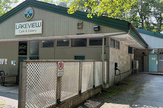 The EV charging station is located on the side of the building next to a gravel path.