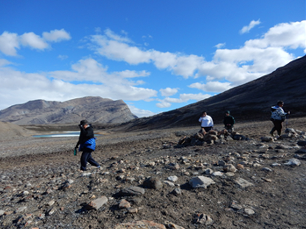 Four people hiking on the tundra.