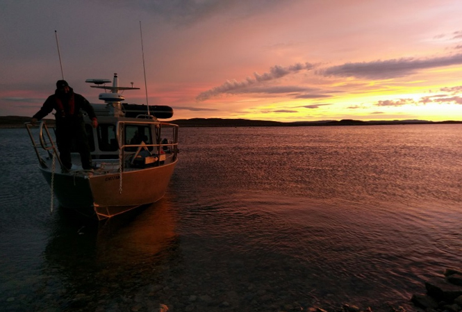 Un bateau sur la baie de Wager au coucher du soleil.