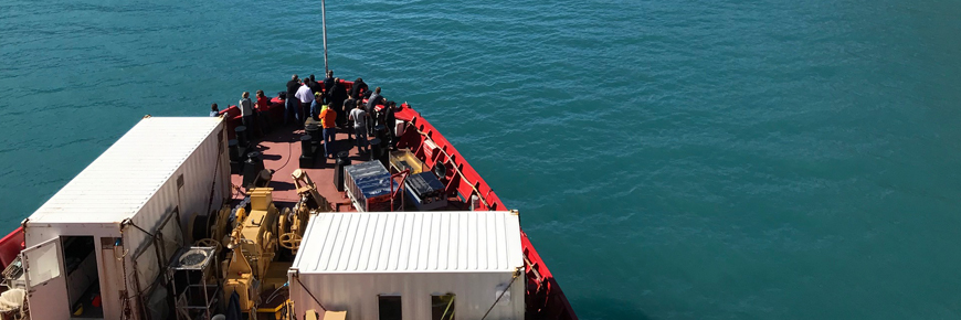 Un groupe de personnes s'est réuni sur la proue d'un brise-glace rouge.