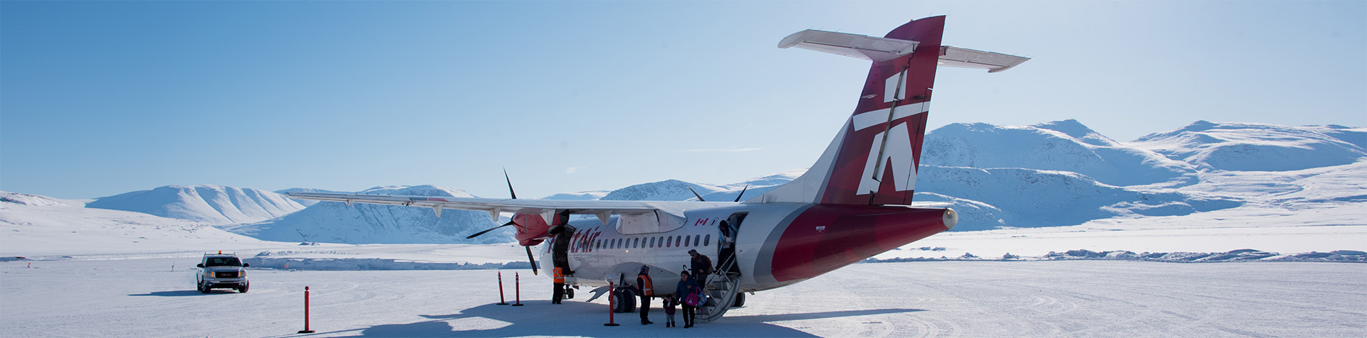 Passengers exiting a plane on the runway in Pangnirtung. 