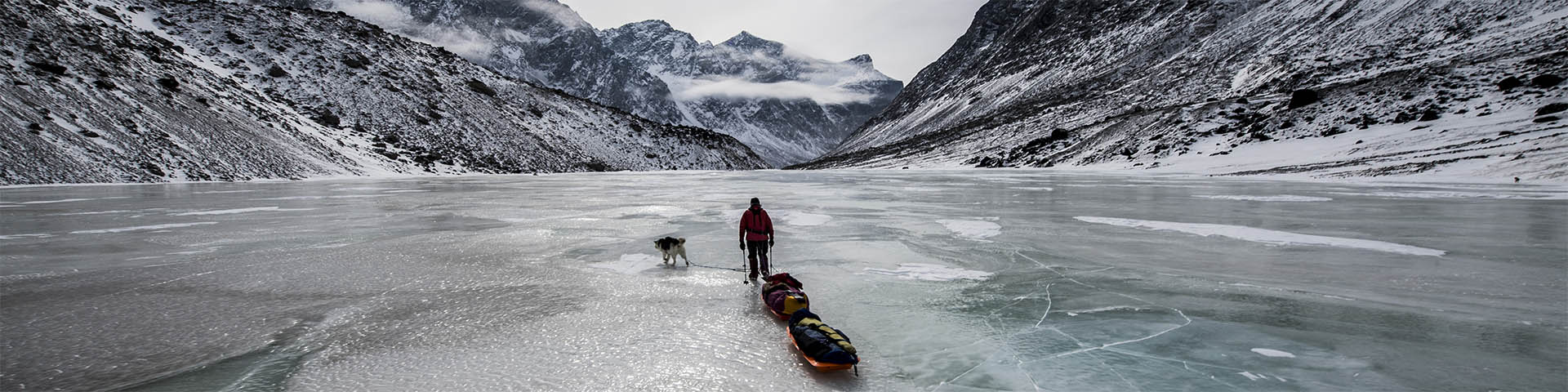 A skier pulling two pulk sleds across the ice in Auyuittuq National Park. 
