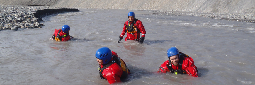 Four search and rescue officers in a river.