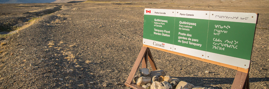 An official Quttinirpaaq National Park sign, in English, French and Inuktitut.