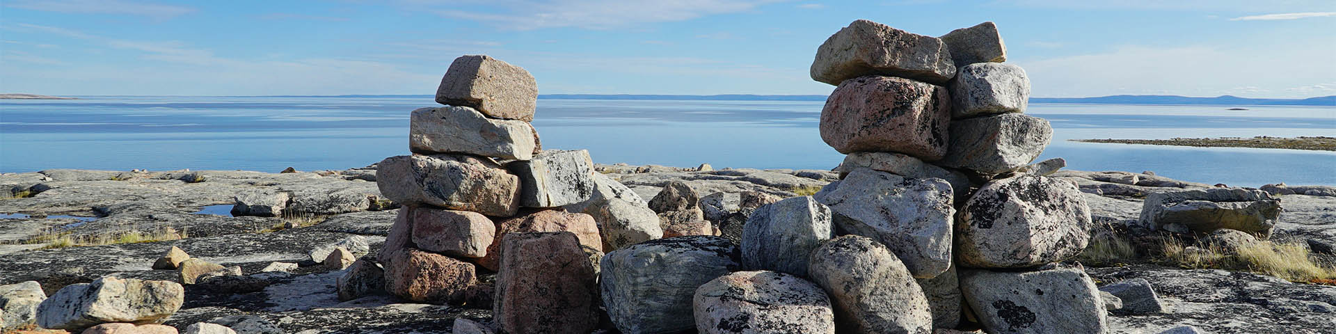 Gros plan sur deux inukshuks surplombant la baie de Wager.