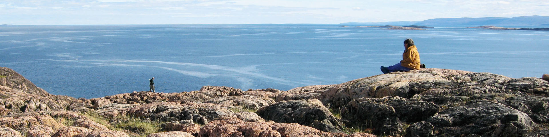A person sitting on a rock overlooking Wager Bay. 