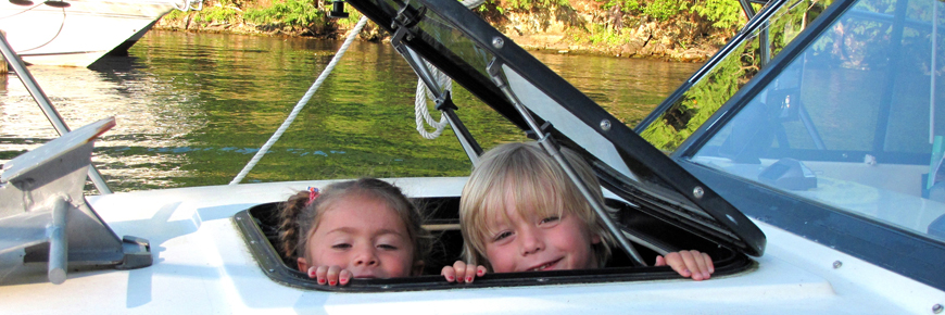 Kids peak out of a window on a boat