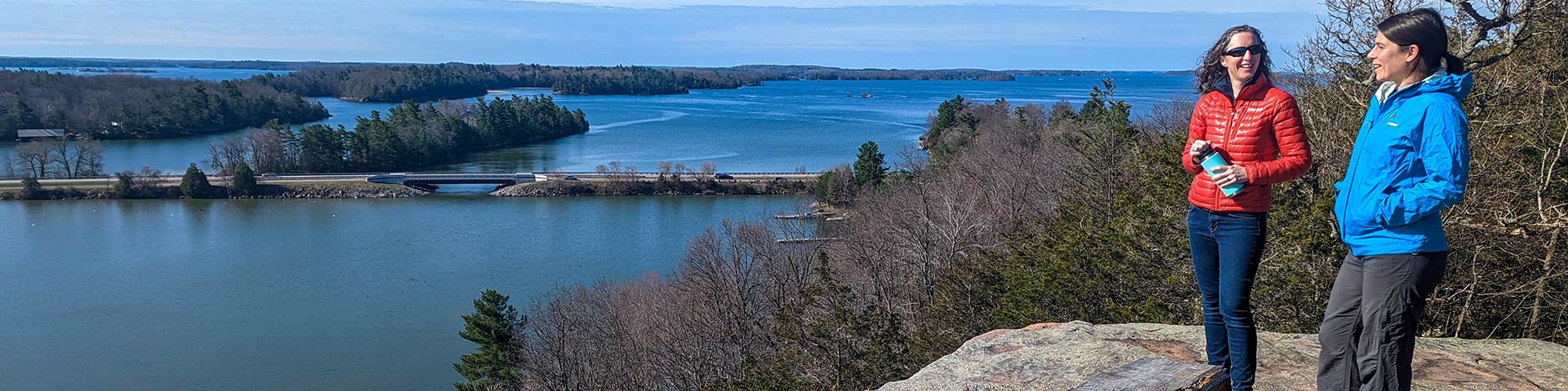 Deux visiteurs à un point de vue sur une baie.