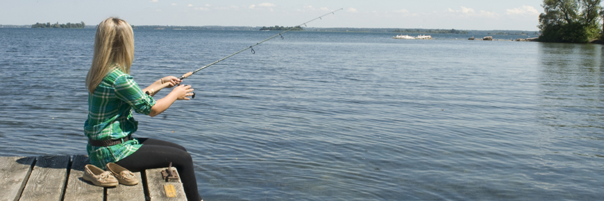 Une femme pêche sur un quai.