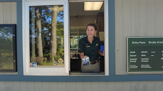 Un membre du personnel de Parcs Canada remet des cartes aux visiteurs