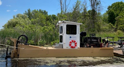 La machine à couper la végétation aquatique du parc est déployée pour la première fois depuis la promenade du marais. 