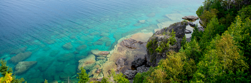 Blue waters next to the rocky shoreline. 