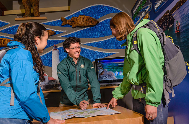A park staff member shows a map to two visitors
