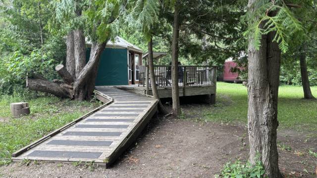 Une rampe d’accessibilité en bois mène à une plateforme surélevée.