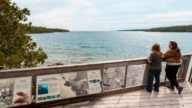 Deux personnes profitent de la vue depuis un belvédère au bord de l’eau.