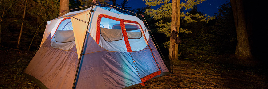 At tent illuminated at night.