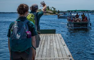 Park staff wave to visitors on a boat