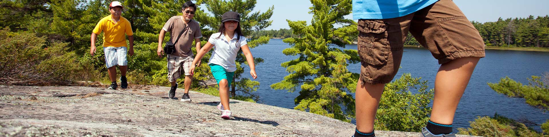 A family hikes across a rocky trail.