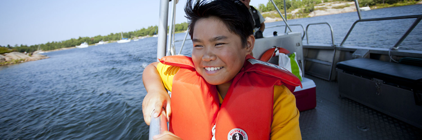 Un enfant aime faire un tour en bateau.