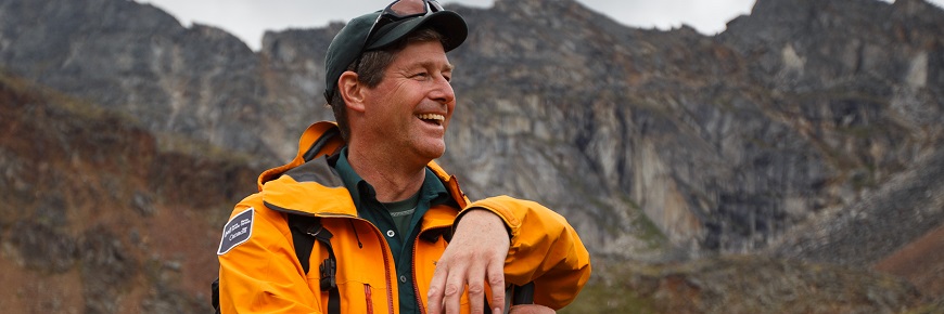 Doug in uniform with mountains behind him.