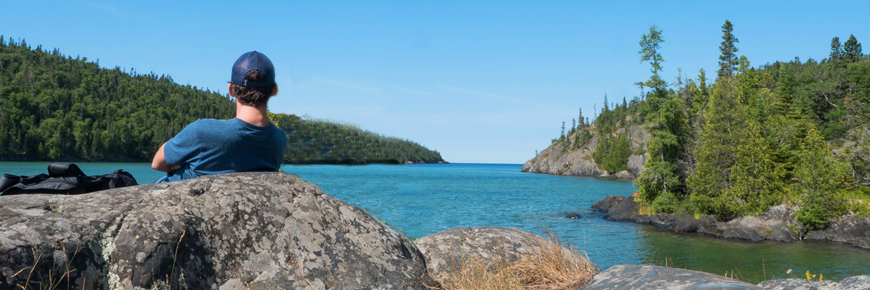 Une personne sur le rivage, regardant le lac Supérieur.