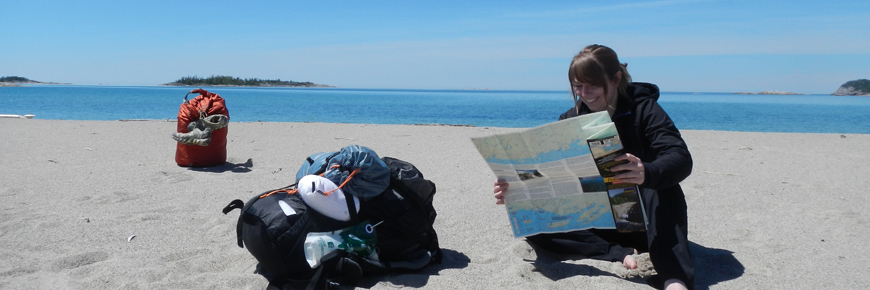 Une personne avec une carte assise sur une plage.