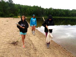 Left to right, Kalysta Collins-Bouchard, Ocean Cherneski, & Baily O'Conner monitoring for invasive species at Louie Lake
