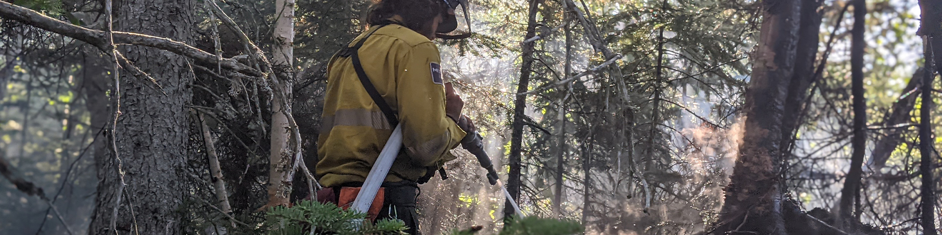 Shaughn Clutchey utilise un tuyau d’arrosage avec une buse pour éteindre un point chaud