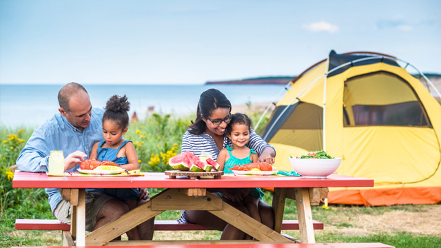 Pique-nique en famille au terrain de camping de Cavendish, parc national de l’Île-du-Prince-Édouard. 