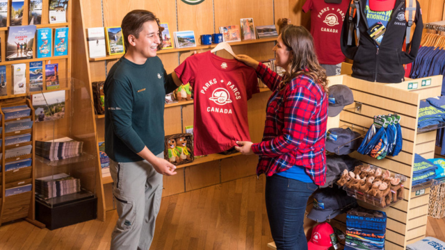 Park Store attendant helping visitor with merchandise. 