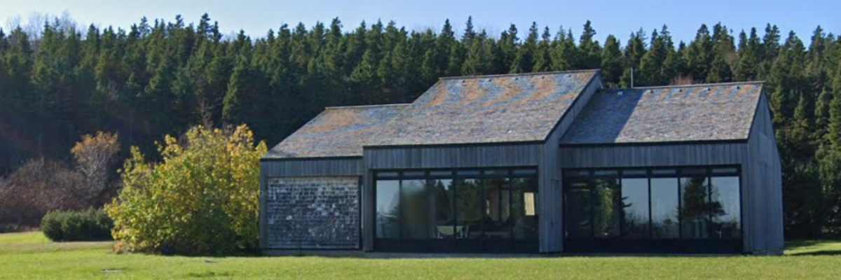 Bâtiment de bois fenestré dans une aire gazonnée