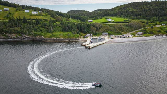 Aerial view of a boat leaving a wharf.