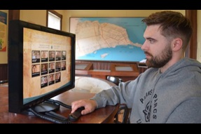 A man looks at an interactive screen in an exhibit.