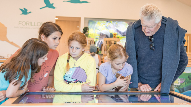 Des enfants et une personne âgée jouent à un jeu interactif numérique.