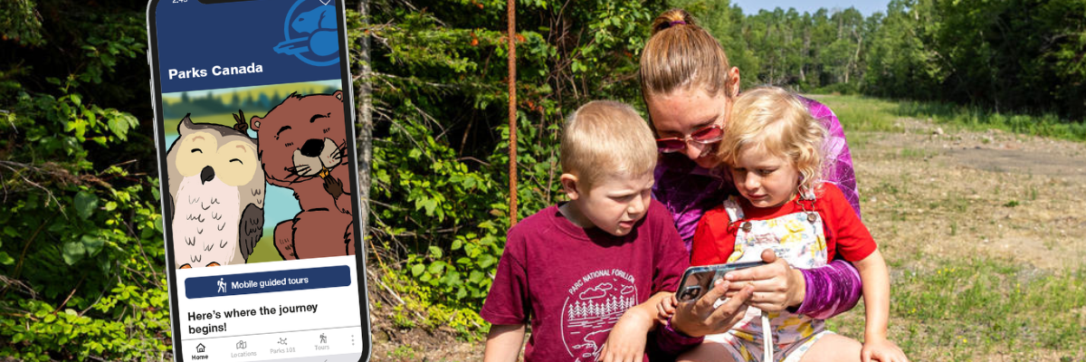 A mother and her two chilren are playing with the app in nature.