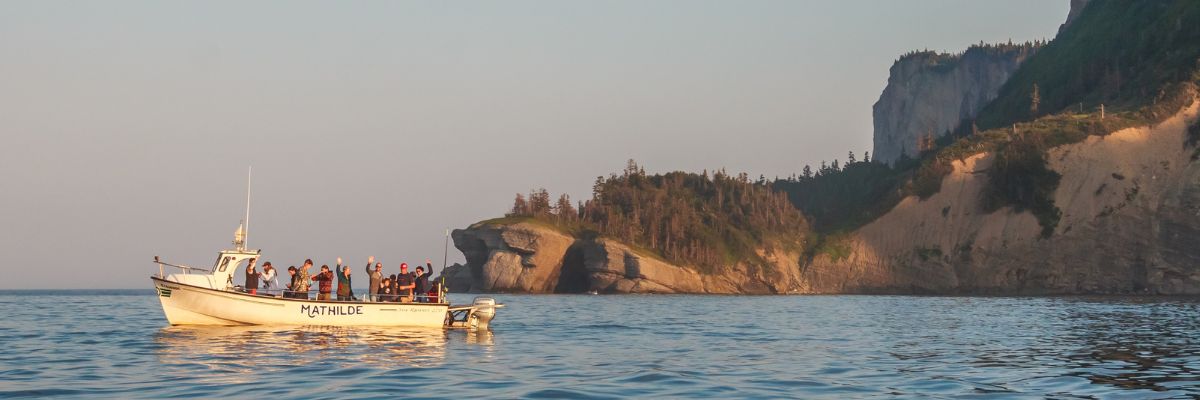 Visitors enjoy a sea outing on the Mathilde near the cliffs of Cap Bon-Ami. 