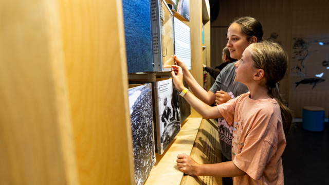 Two young visitors explore the park ecosystem interactive module.