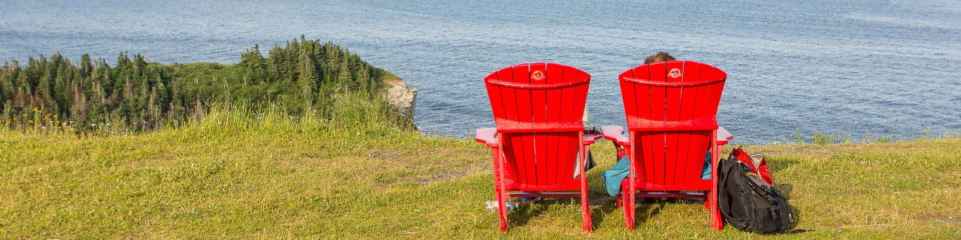 Two red chairs facing the Gulf of St. Lawrence estuary 