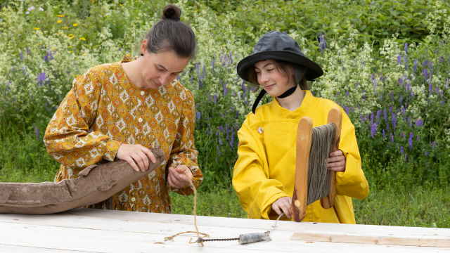 Visitors wearing period costumes of a farmer and a fisherman.