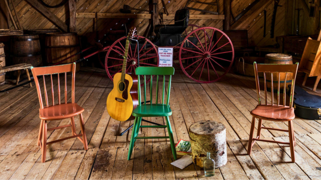 Instruments de musique et chaises anciennes dans une grange.